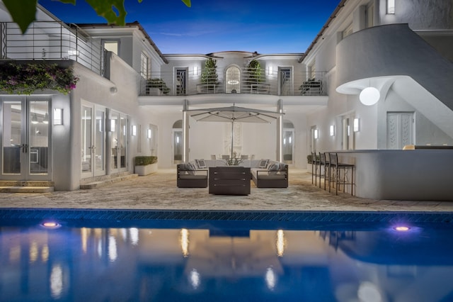 view of pool featuring outdoor lounge area, an outdoor bar, a patio, and french doors