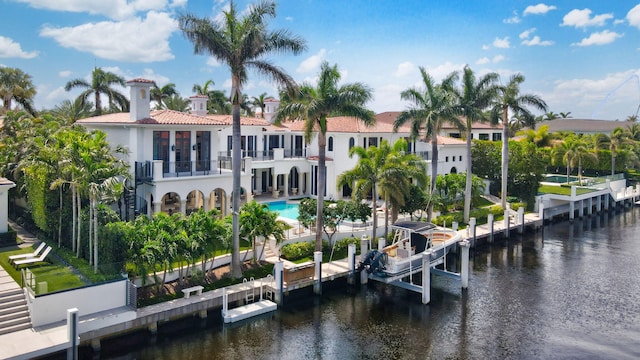 rear view of house featuring a balcony and a water view