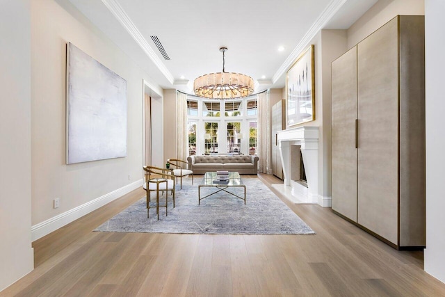 interior space featuring an inviting chandelier, a tray ceiling, and light hardwood / wood-style flooring