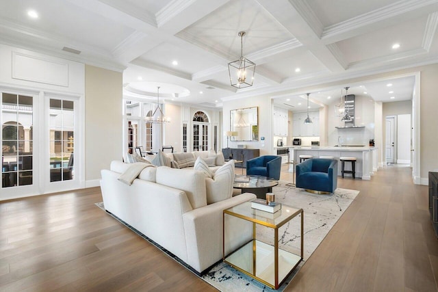 living room featuring coffered ceiling, beam ceiling, and a notable chandelier