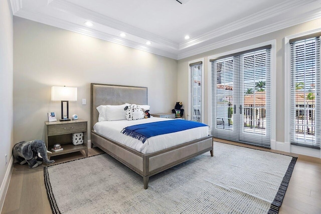 bedroom featuring hardwood / wood-style flooring, crown molding, and access to outside