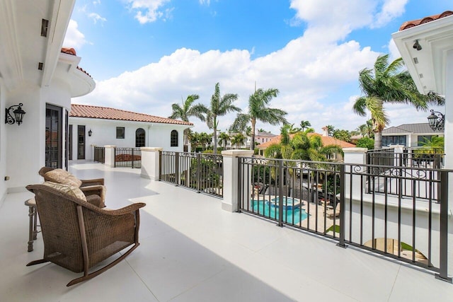 view of patio featuring a balcony and a fenced in pool