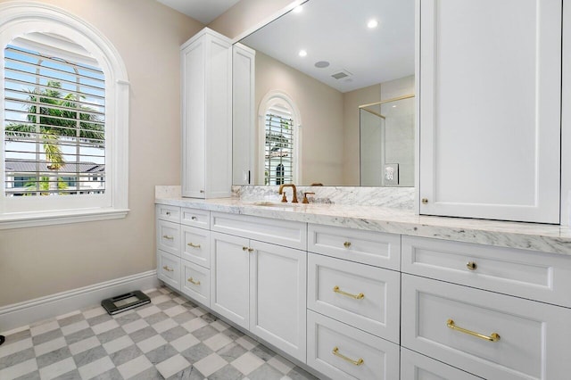 bathroom with vanity, a shower, and a wealth of natural light