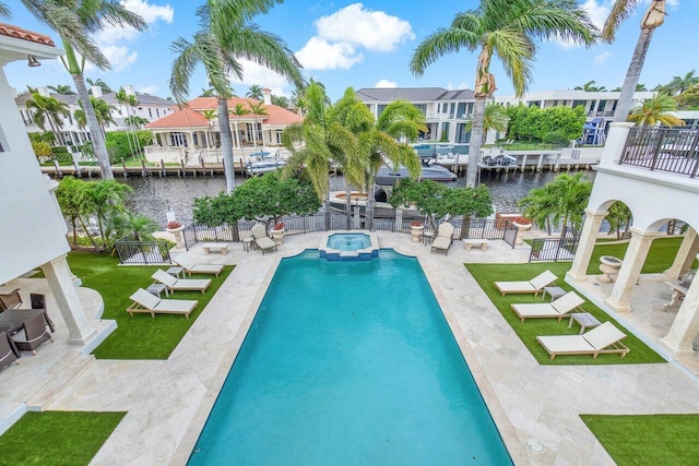 view of swimming pool featuring a water view, a yard, an in ground hot tub, and a patio area