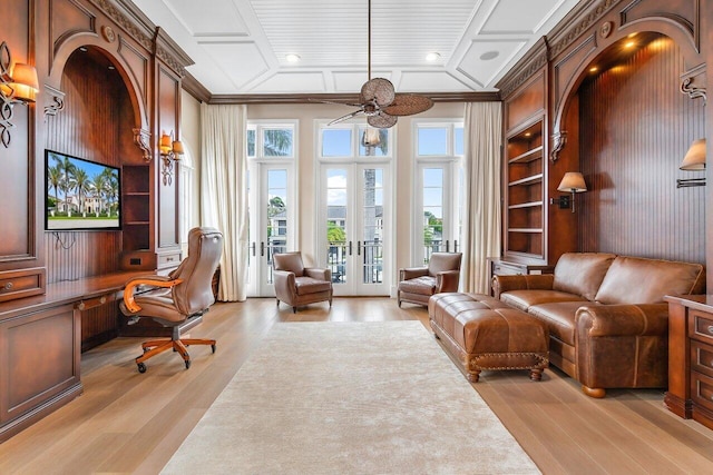 sitting room featuring crown molding, ceiling fan, coffered ceiling, built in desk, and french doors