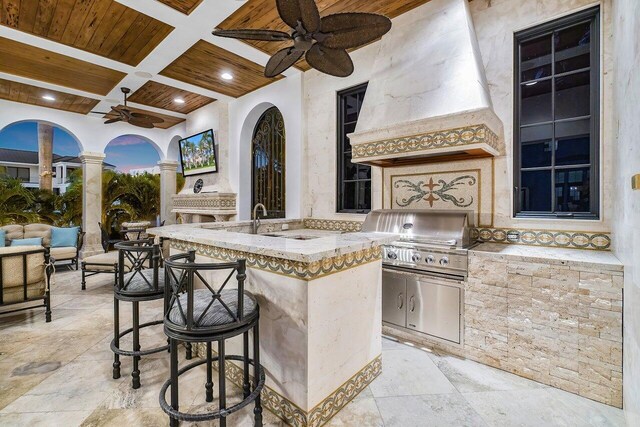 view of patio / terrace with ceiling fan, a grill, area for grilling, and a wet bar