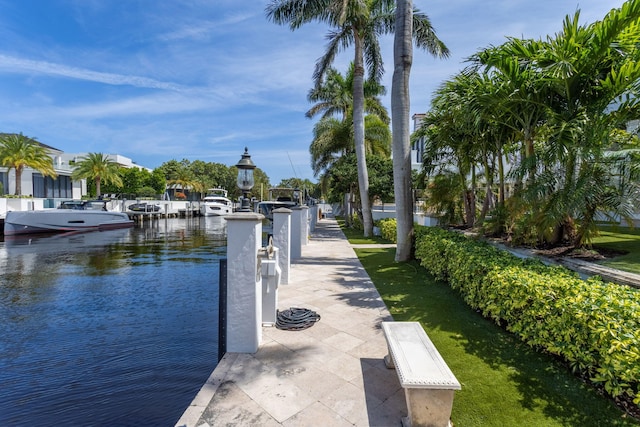 view of dock featuring a water view and a yard