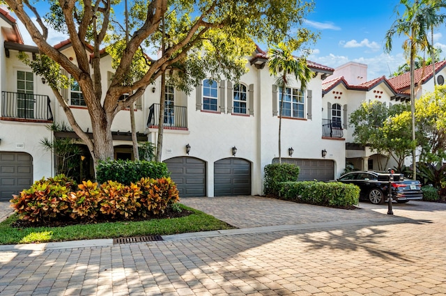 1583 Estuary Trl, Delray Beach, FL 33483 - view of front facade featuring a tiled roof, a balcony, stucco siding, an attached garage, and driveway