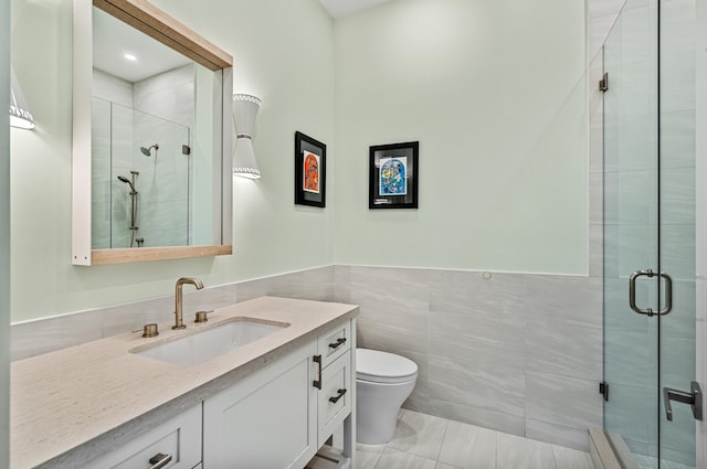 bathroom featuring tile walls, tile patterned flooring, an enclosed shower, vanity, and toilet