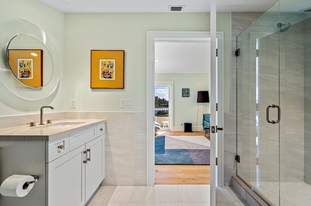 bathroom with vanity, hardwood / wood-style flooring, and a shower with shower door