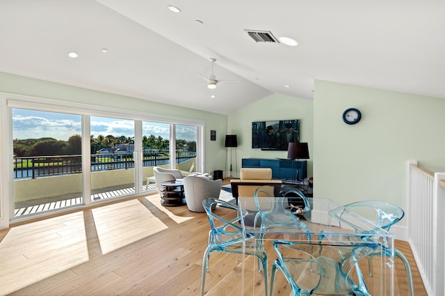 dining space featuring light wood-type flooring, vaulted ceiling, and ceiling fan