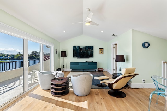 living room featuring light hardwood / wood-style floors, vaulted ceiling, and ceiling fan