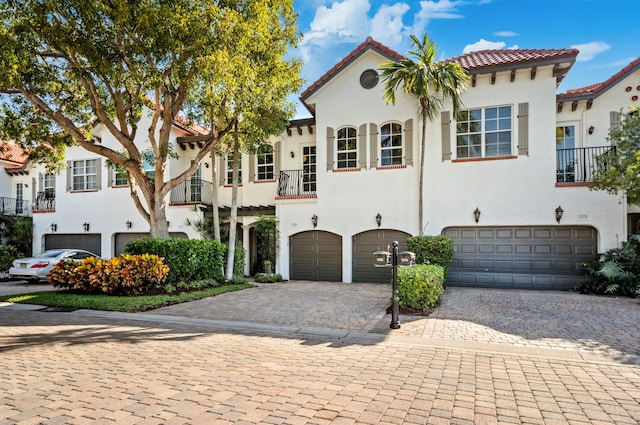 1583 Estuary Trl, Delray Beach, FL 33483 - mediterranean / spanish-style home with an attached garage, a tiled roof, stucco siding, and decorative driveway