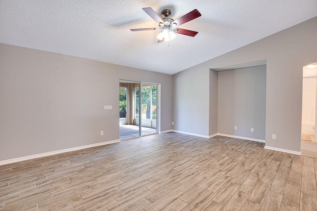 spare room with ceiling fan, a textured ceiling, lofted ceiling, and light hardwood / wood-style flooring