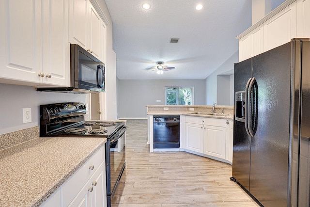 kitchen featuring black appliances, light hardwood / wood-style flooring, and white cabinets