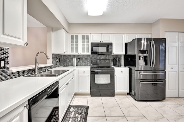 kitchen with black appliances, decorative backsplash, white cabinets, sink, and a textured ceiling