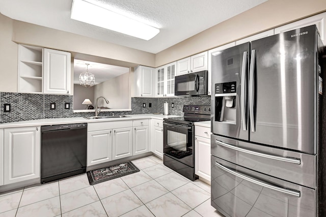 kitchen with tasteful backsplash, decorative light fixtures, sink, black appliances, and white cabinetry