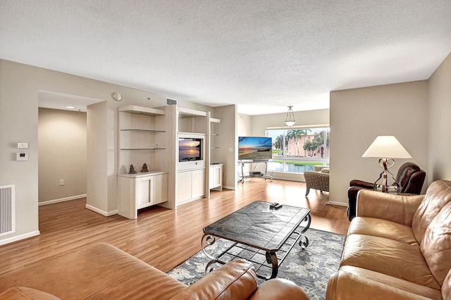 living room with light hardwood / wood-style floors and a textured ceiling