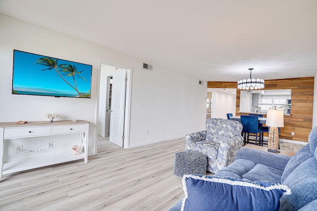 living room with light hardwood / wood-style flooring and wood walls