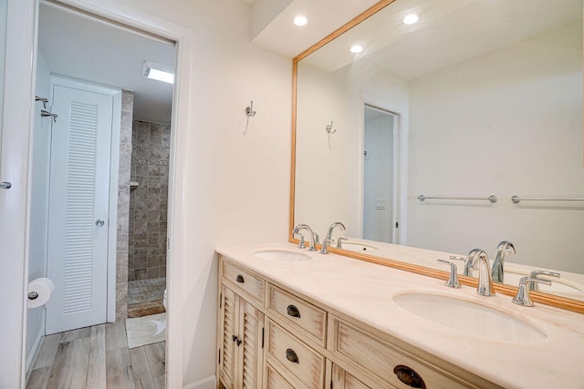 bathroom with vanity, hardwood / wood-style floors, and tiled shower