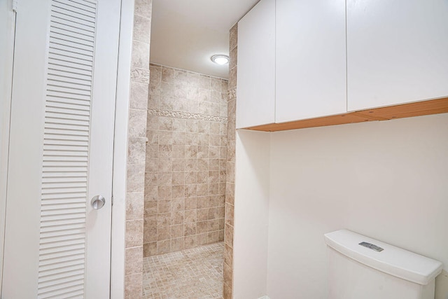 bathroom featuring toilet and tiled shower