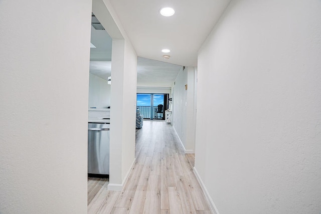 corridor with light hardwood / wood-style floors