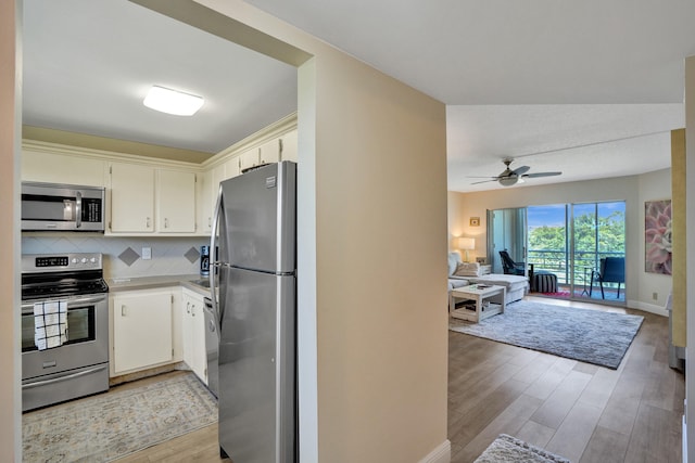 kitchen featuring appliances with stainless steel finishes, light hardwood / wood-style floors, ceiling fan, and tasteful backsplash