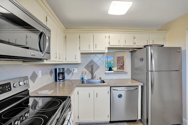 kitchen with stainless steel appliances, backsplash, sink, and cream cabinetry