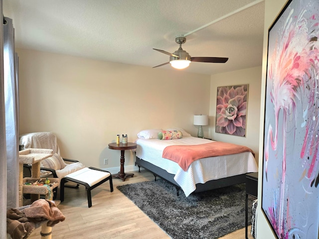 bedroom featuring a textured ceiling, ceiling fan, and light hardwood / wood-style flooring