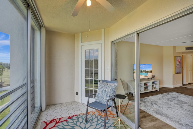 sunroom / solarium featuring ceiling fan