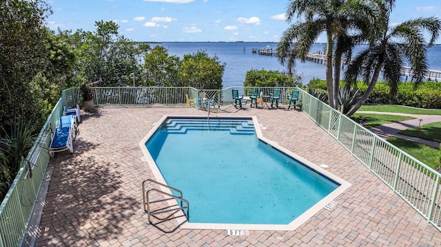 view of swimming pool with a patio and a water view