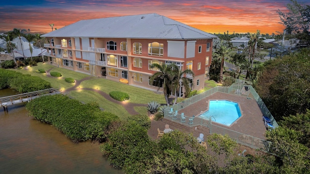 aerial view at dusk featuring a water view