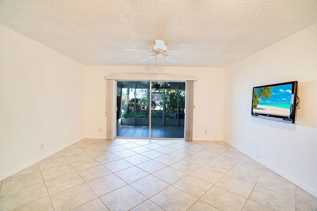 empty room with ceiling fan, a textured ceiling, and light tile patterned floors