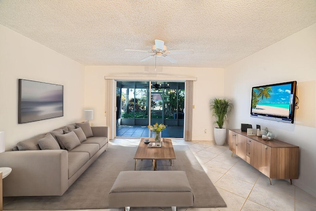 living room with ceiling fan, a textured ceiling, and light tile patterned floors