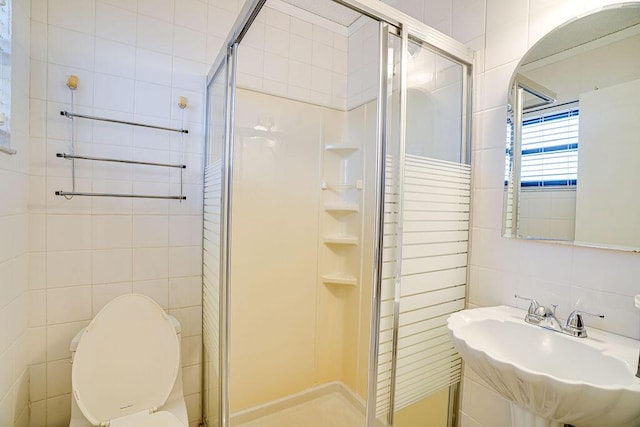 9427 S Ocean Dr Unit 60, Jensen Beach, FL 34957 - bathroom featuring a shower stall, tile walls, toilet, and a sink