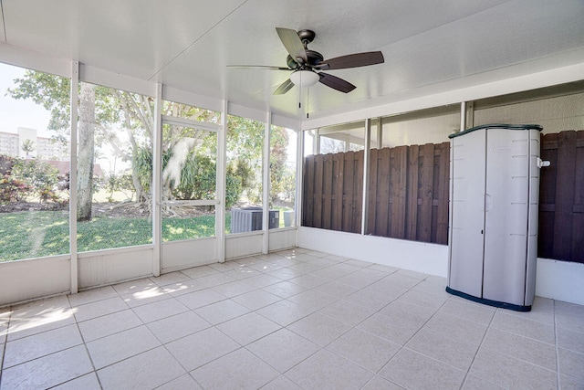 unfurnished sunroom featuring ceiling fan and a healthy amount of sunlight