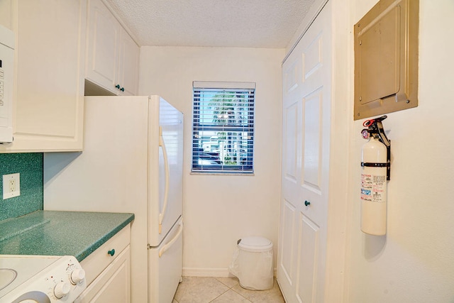 kitchen with white cabinets, a textured ceiling, electric panel, and light tile patterned flooring