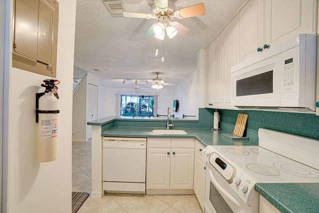 kitchen featuring a textured ceiling, sink, kitchen peninsula, and white appliances