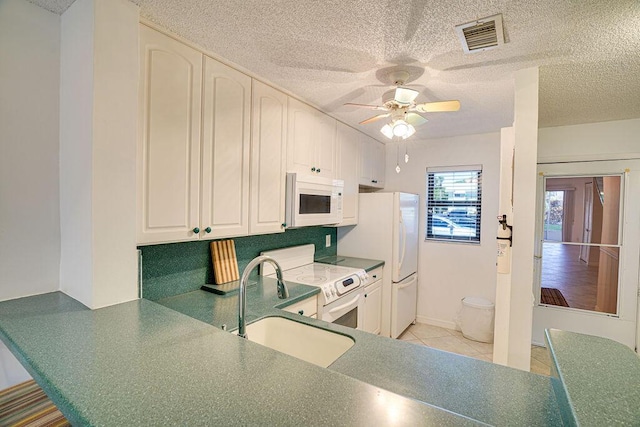 9427 S Ocean Dr Unit 60, Jensen Beach, FL 34957 - kitchen with visible vents, a sink, white appliances, a textured ceiling, and ceiling fan