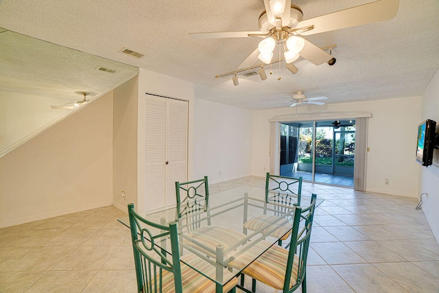 dining area featuring a textured ceiling, light tile patterned flooring, and ceiling fan