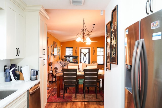 dining space featuring a notable chandelier, vaulted ceiling, and dark wood-type flooring