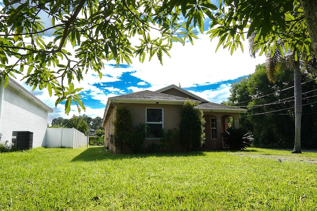 view of front facade featuring central AC unit and a front lawn