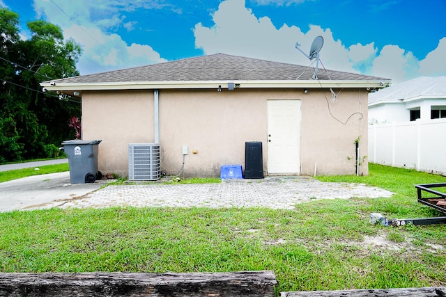 back of property with a lawn and central air condition unit