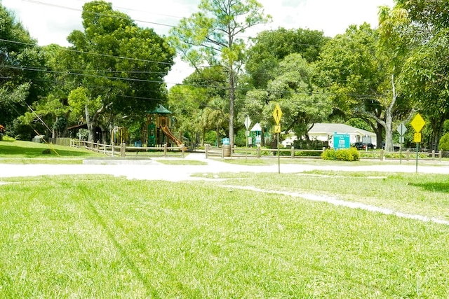 view of home's community featuring a playground and a lawn