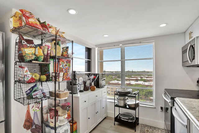 kitchen featuring white cabinets, light wood-type flooring, and stainless steel appliances