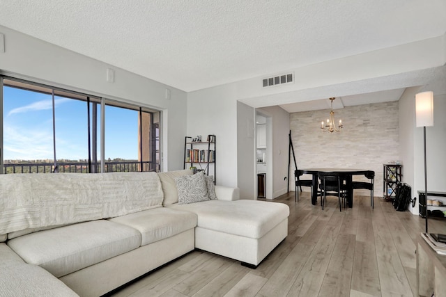 living room with hardwood / wood-style flooring, a textured ceiling, and a chandelier