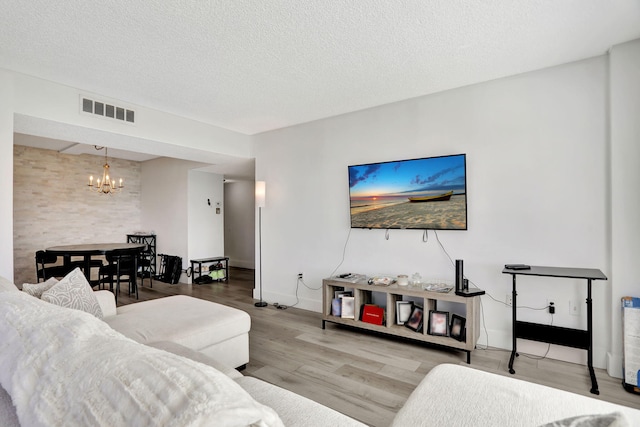 living room featuring a chandelier, hardwood / wood-style floors, and a textured ceiling