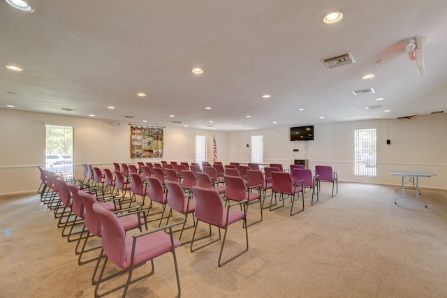 carpeted home theater room featuring a textured ceiling