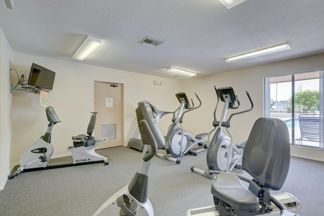 workout area with carpet and a textured ceiling