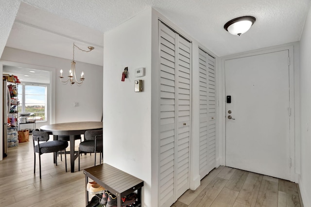4174 Inverrary Dr Unit 914, Lauderhill, FL 33319 - entryway featuring light wood-type flooring, a textured ceiling, and a chandelier